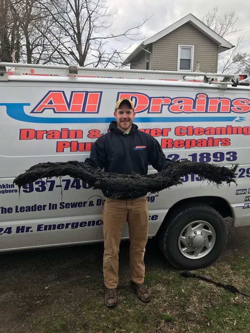 Technician holding a large root mass in front of service van